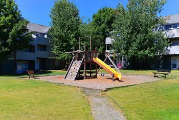 a playground with a swing set in front of a building
